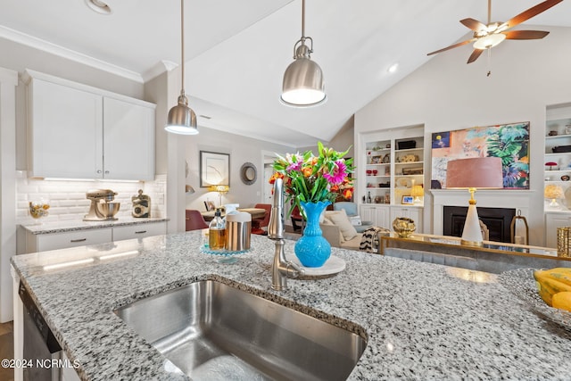 kitchen featuring white cabinetry, decorative light fixtures, light stone counters, ceiling fan, and vaulted ceiling