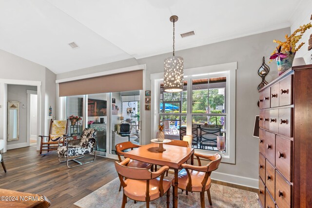 dining room featuring dark hardwood / wood-style floors, a notable chandelier, and vaulted ceiling