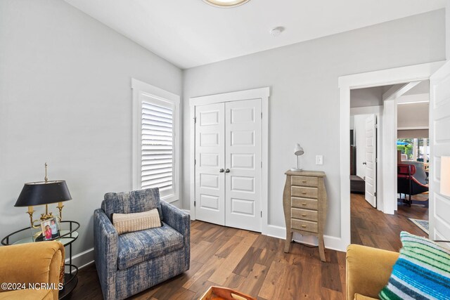 living area with a healthy amount of sunlight and dark wood-type flooring