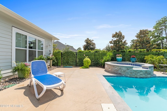 view of pool featuring an in ground hot tub and a patio