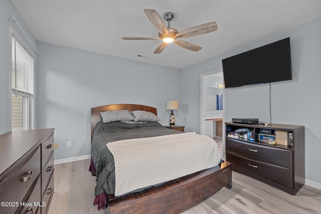 bedroom with ceiling fan, ensuite bathroom, and light hardwood / wood-style floors