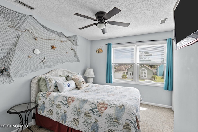 carpeted bedroom featuring ceiling fan and a textured ceiling