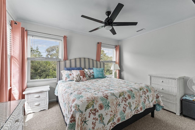 bedroom with multiple windows, ceiling fan, crown molding, and light colored carpet