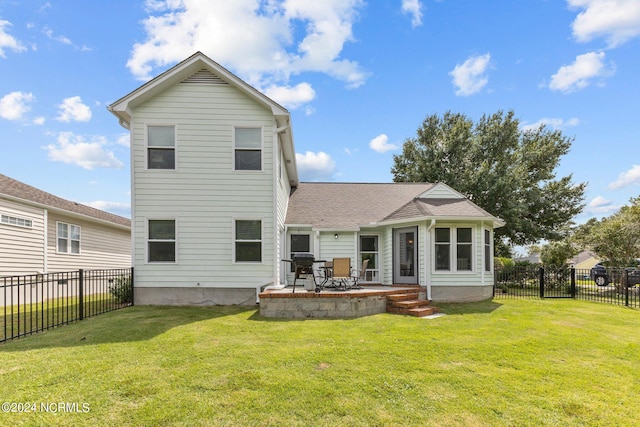 back of property with a yard and a patio