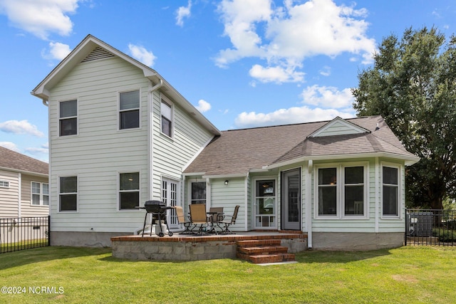 back of property with a yard and a patio