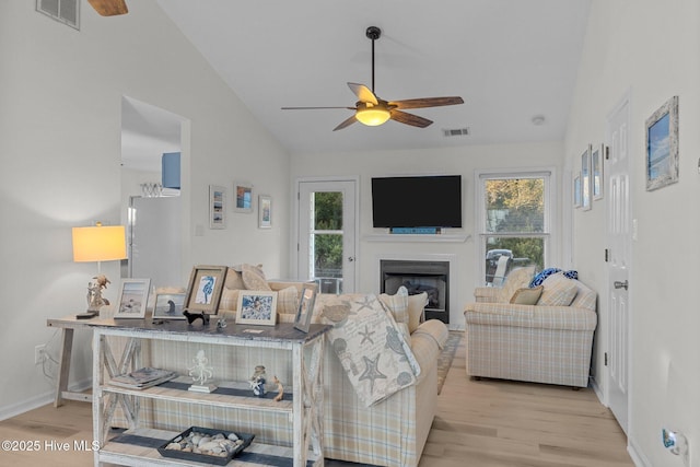 living room featuring light hardwood / wood-style floors, ceiling fan, and lofted ceiling