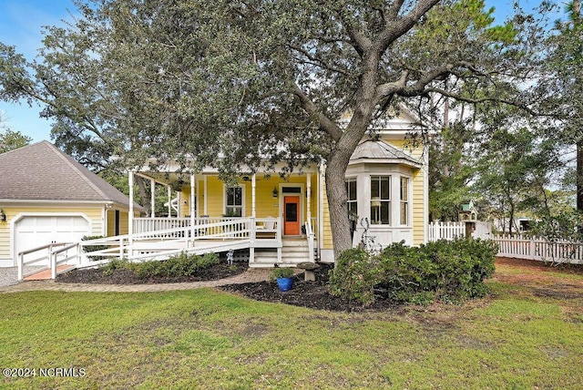 view of front facade with covered porch, a front yard, and a garage