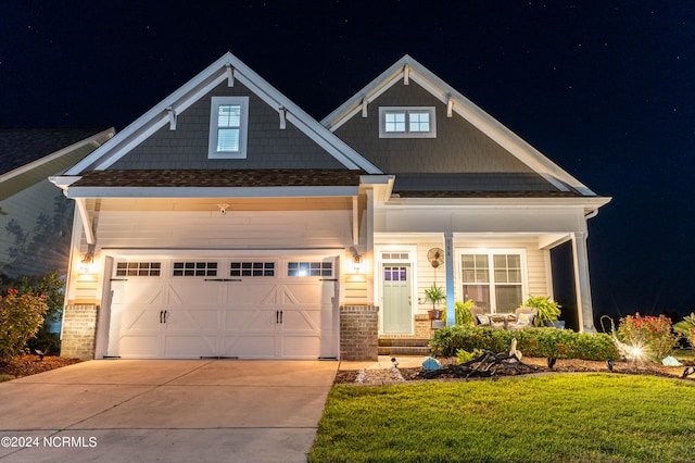 craftsman-style house featuring a lawn, a porch, and a garage