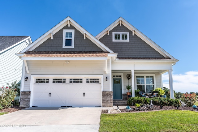 craftsman-style home featuring a garage, a front lawn, and a porch