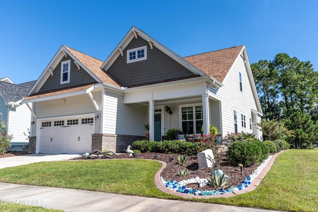 craftsman-style house featuring a front yard, a garage, and covered porch