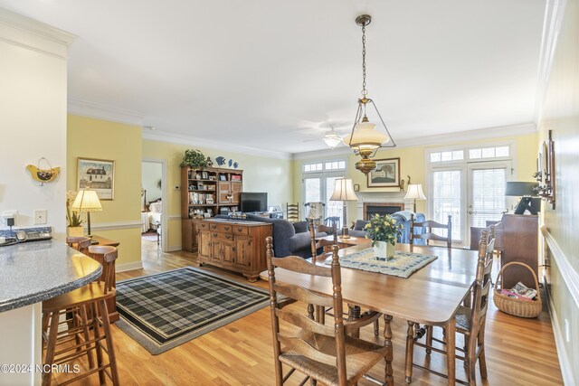 dining area featuring crown molding, a wealth of natural light, and light hardwood / wood-style floors