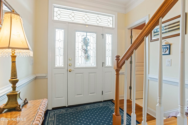 foyer entrance with wood-type flooring and crown molding