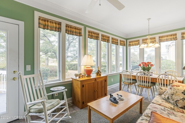 sunroom / solarium with ceiling fan with notable chandelier and plenty of natural light