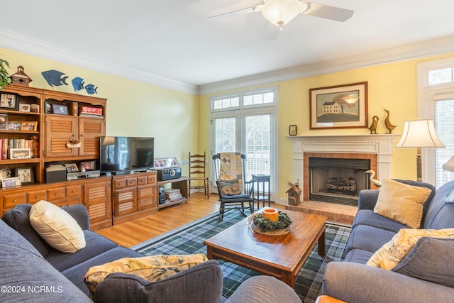 living room featuring a healthy amount of sunlight, ceiling fan, and a brick fireplace