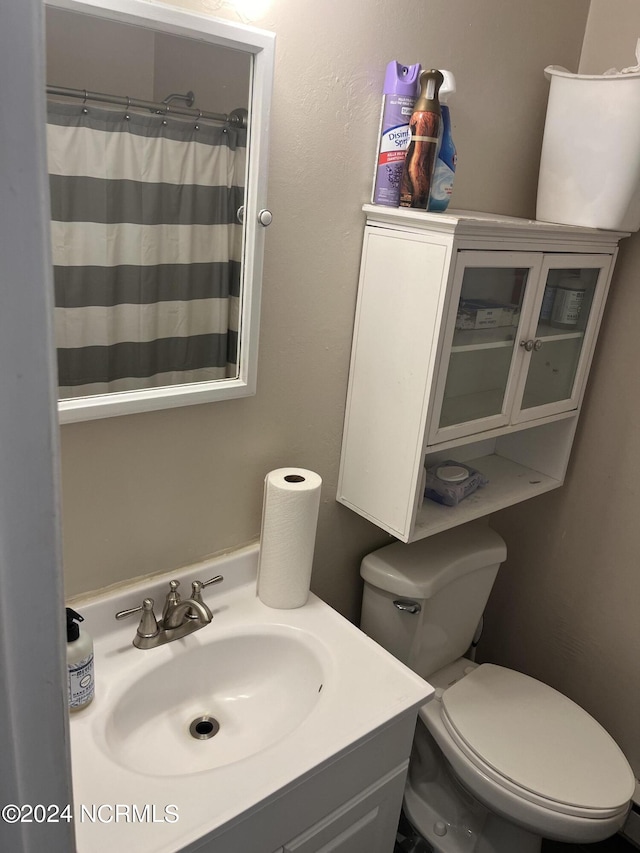 bathroom with vanity, toilet, and curtained shower