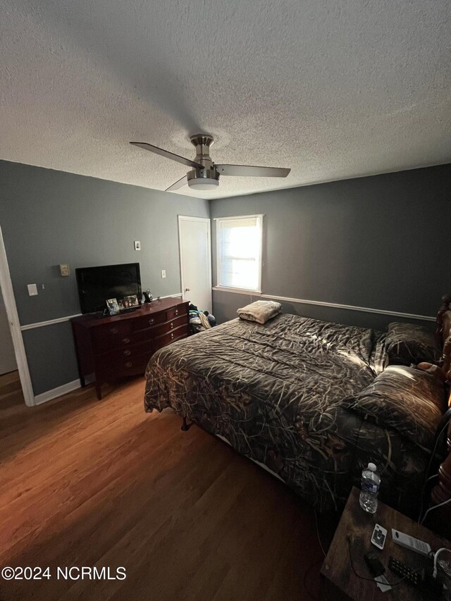 bedroom featuring a textured ceiling, ceiling fan, and hardwood / wood-style floors