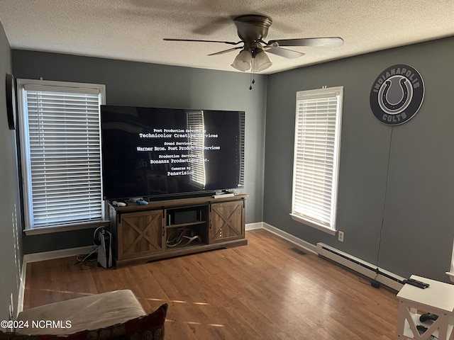 living room with a textured ceiling, wood-type flooring, and ceiling fan