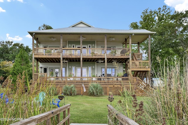 back of property with a lawn, a wooden deck, stairs, and ceiling fan