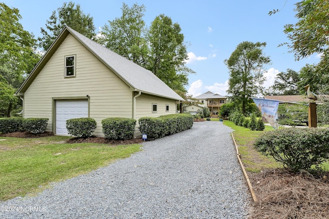 view of side of property featuring a detached garage and a lawn