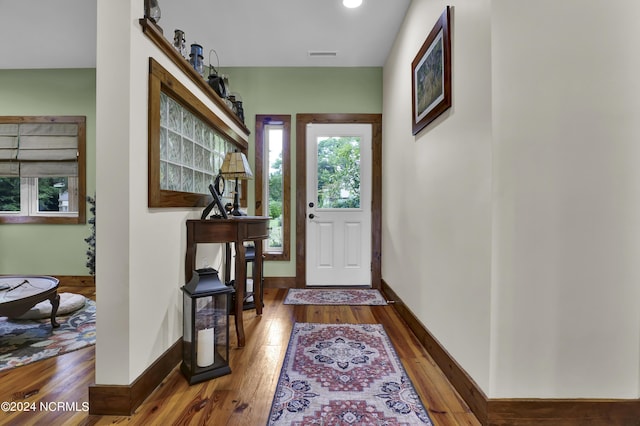 foyer featuring baseboards, visible vents, and wood-type flooring