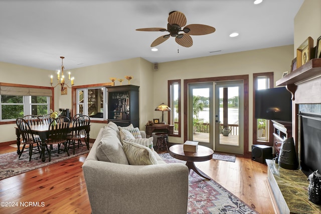 living room featuring a premium fireplace, plenty of natural light, french doors, and hardwood / wood-style floors