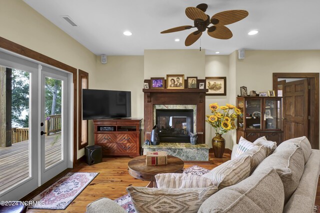 living room with recessed lighting, visible vents, wood finished floors, and a high end fireplace