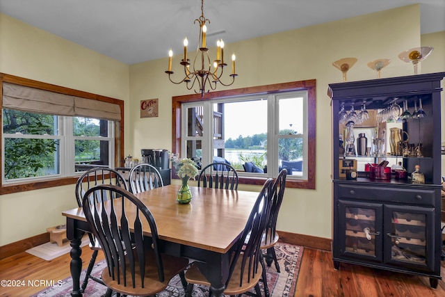 dining space with a chandelier, plenty of natural light, baseboards, and wood finished floors