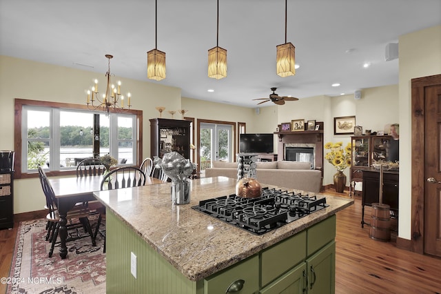 kitchen featuring dark wood finished floors, plenty of natural light, black gas stovetop, and green cabinetry