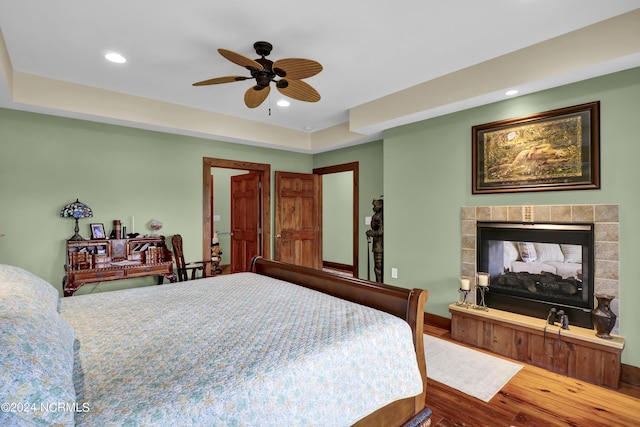 bedroom featuring recessed lighting, a ceiling fan, wood finished floors, and a fireplace