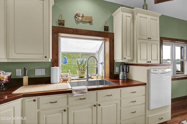 kitchen with a wealth of natural light, tile countertops, white dishwasher, and a sink