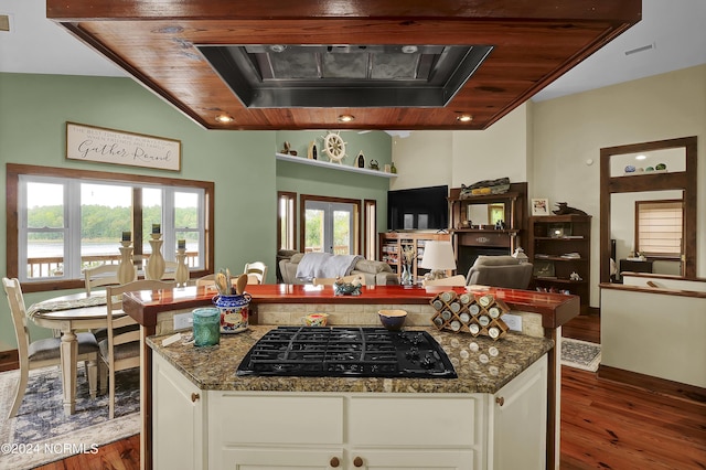 kitchen featuring dark stone countertops, black gas stovetop, dark wood-style flooring, and a center island