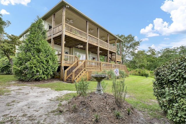 back of property with a deck, stairway, a yard, and a ceiling fan