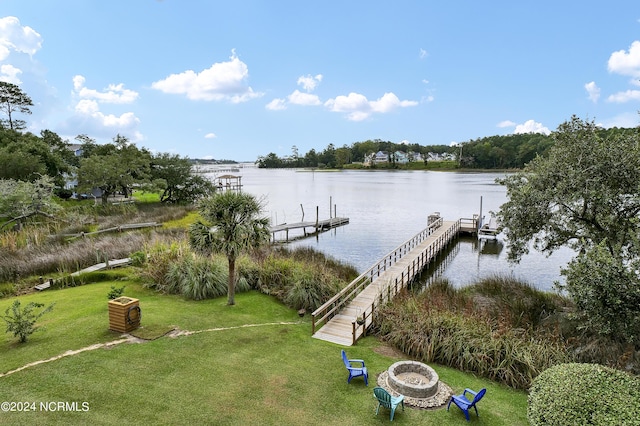 view of dock featuring a yard, a water view, and an outdoor fire pit