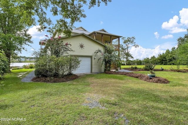 view of property exterior featuring a yard, a balcony, and driveway