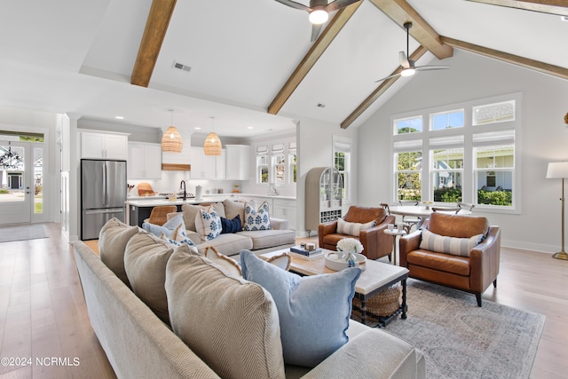 living room featuring high vaulted ceiling, light wood-type flooring, ceiling fan, and beamed ceiling