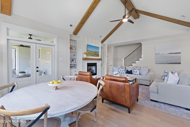 dining room featuring lofted ceiling with beams, ceiling fan, built in features, light wood-type flooring, and french doors