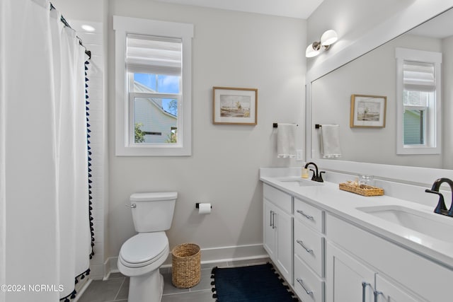 bathroom with toilet, vanity, a healthy amount of sunlight, and tile patterned floors