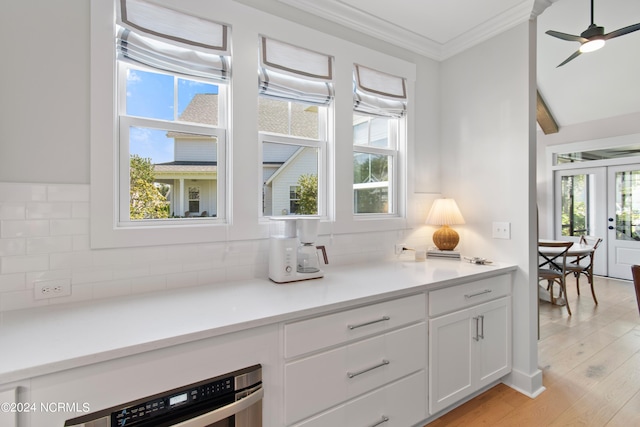 kitchen featuring ornamental molding, a wealth of natural light, light hardwood / wood-style floors, and white cabinets