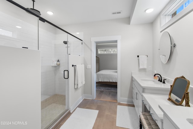 bathroom featuring hardwood / wood-style flooring, vanity, and an enclosed shower