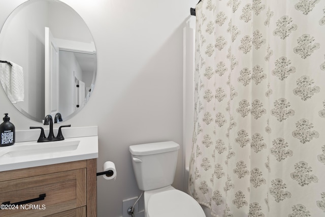 bathroom with toilet, vanity, and a shower with shower curtain