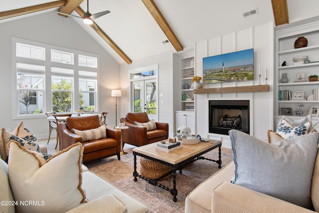 living room with built in shelves, high vaulted ceiling, a wealth of natural light, and beamed ceiling