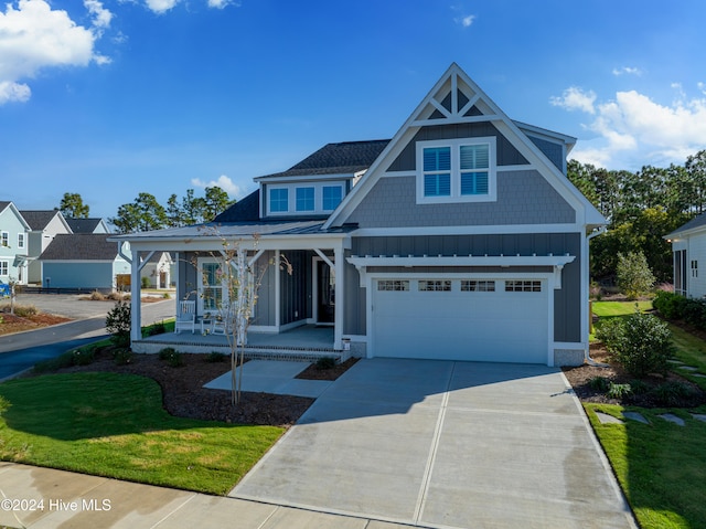 view of front facade with a garage, covered porch, and a front lawn