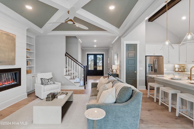 living room featuring french doors, light hardwood / wood-style floors, ceiling fan, crown molding, and lofted ceiling with beams