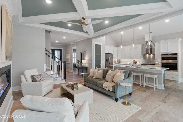 living room with sink, ceiling fan, beam ceiling, light hardwood / wood-style flooring, and coffered ceiling