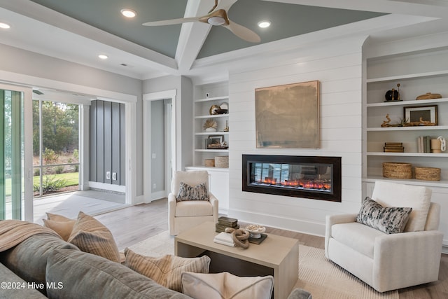 living room with light wood-type flooring, a fireplace, ceiling fan, and built in features