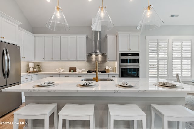 kitchen with a kitchen island with sink and appliances with stainless steel finishes