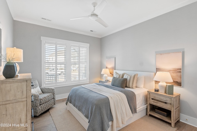 bedroom featuring ornamental molding, light hardwood / wood-style floors, and ceiling fan