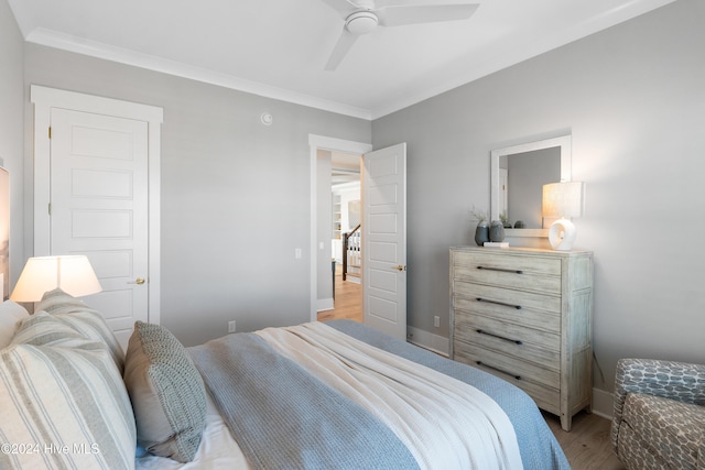 bedroom featuring hardwood / wood-style flooring, ceiling fan, and ornamental molding