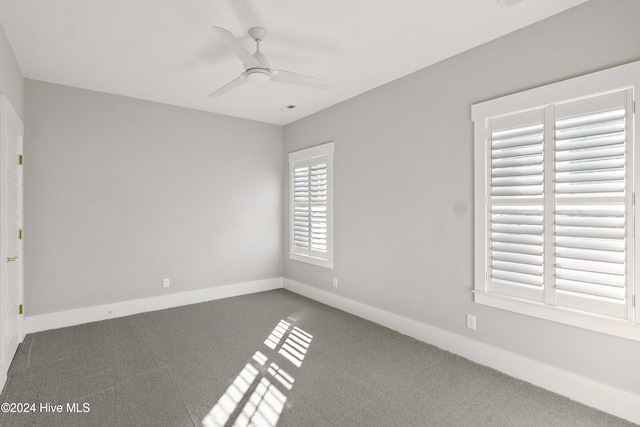 carpeted spare room with ceiling fan