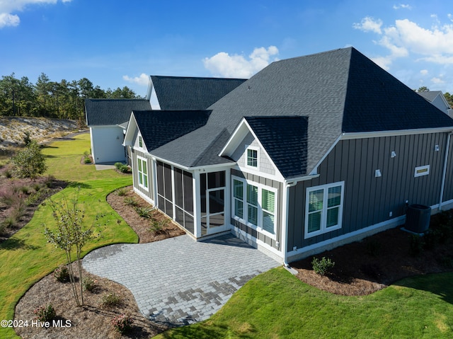 rear view of house with a sunroom and a yard